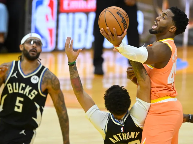 Cleveland Cavaliers Donovan Mitchell drives to the basket beside Milwaukee Bucks Cole Anthony and Gary Trent Jr